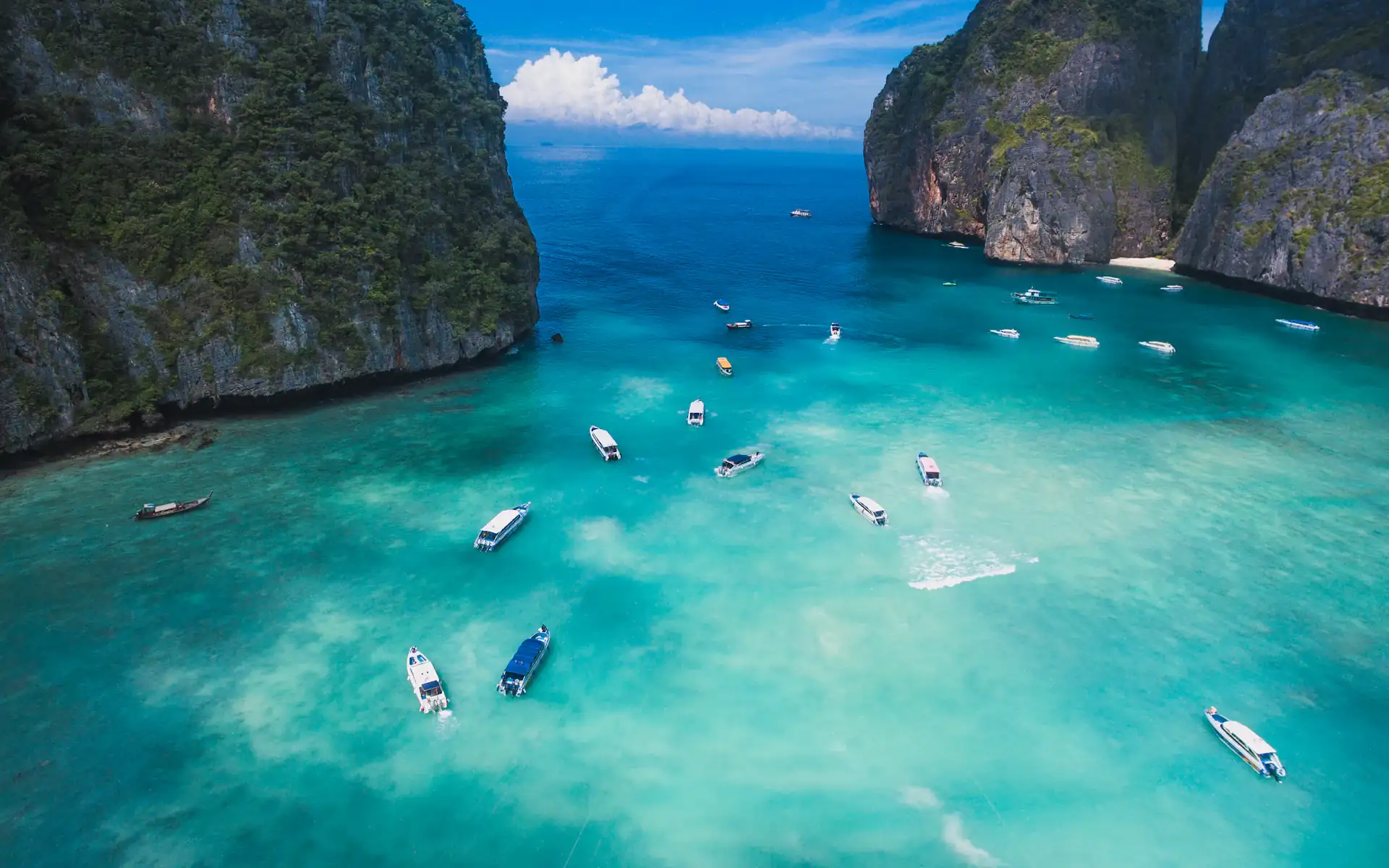Boats in Maya Bay between limestone cliffs