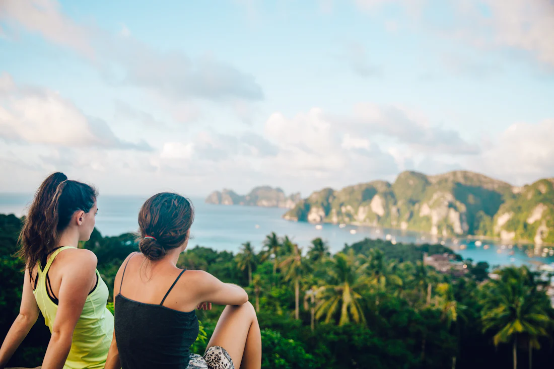 Two girls admiring the sea view from a hill